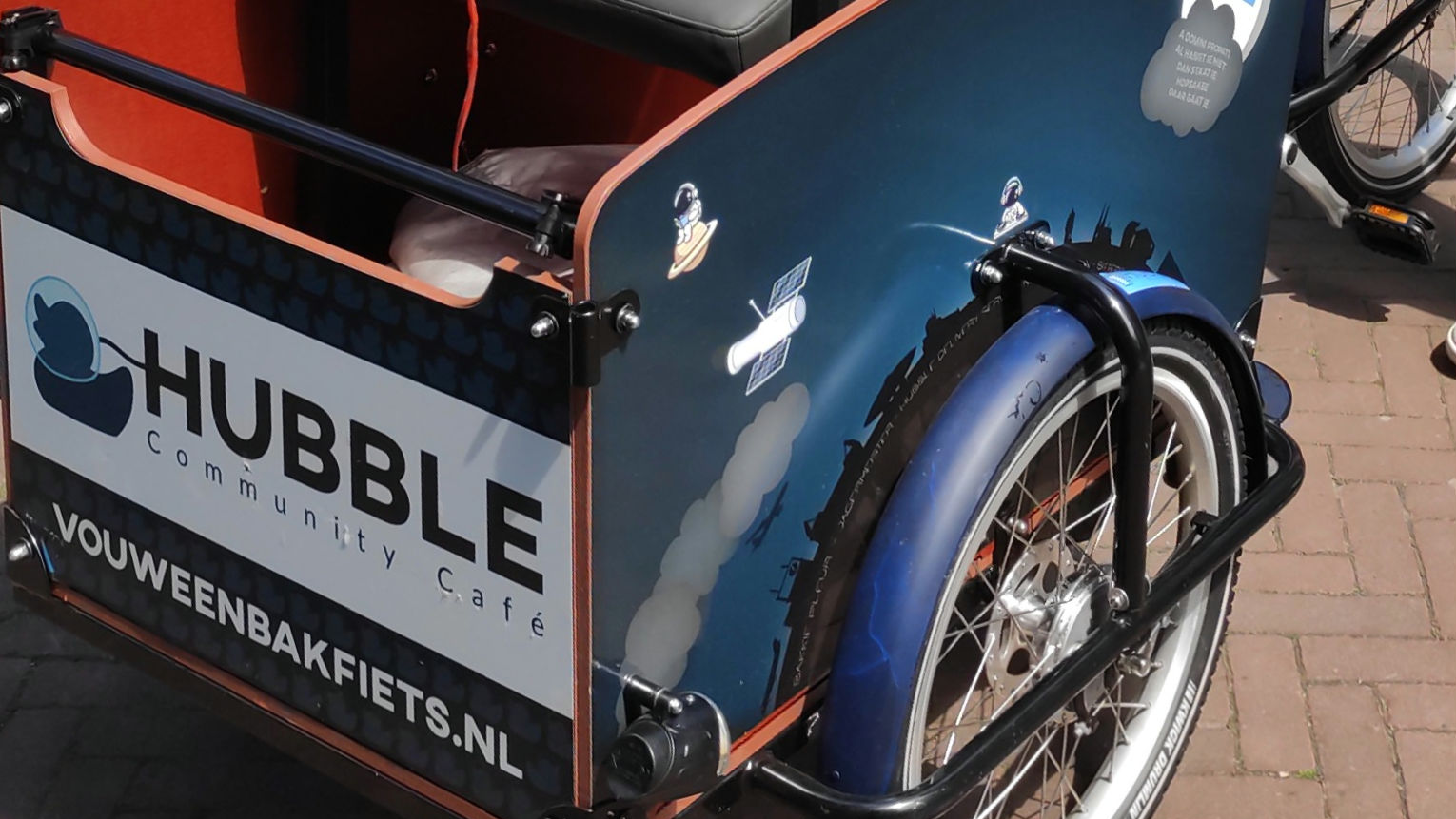 De vouweenbakfiets met het Hubble Community Café bord op de bak.